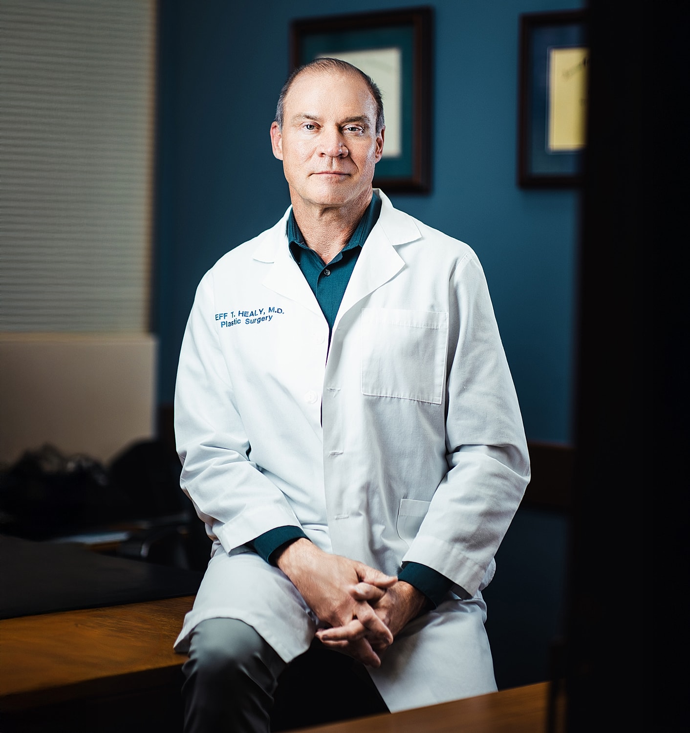 Doctor in white coat posing for photograph.