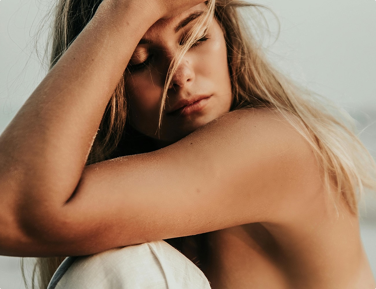 Woman resting her head on her arm.