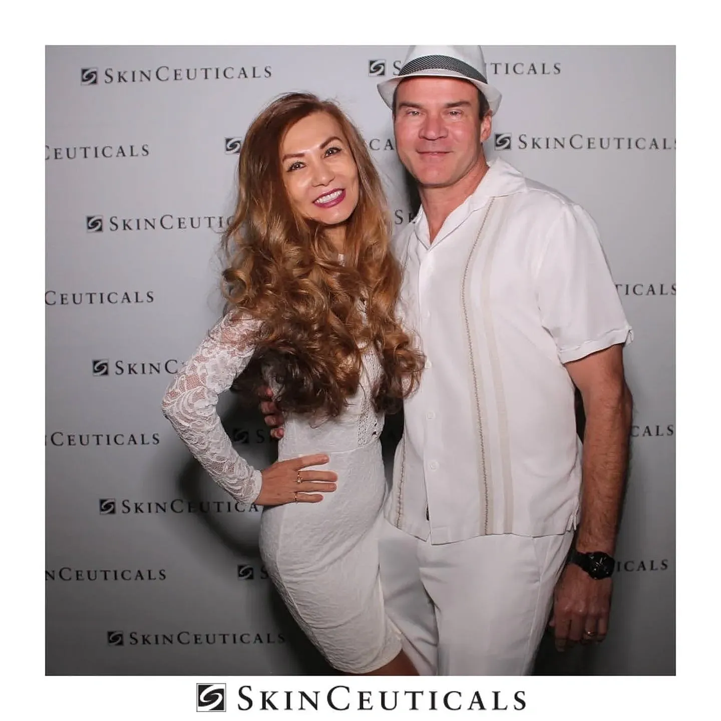 Smiling woman in white dress by a pool.