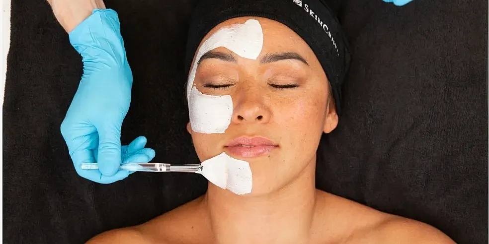 Person receiving a facial treatment with cream.