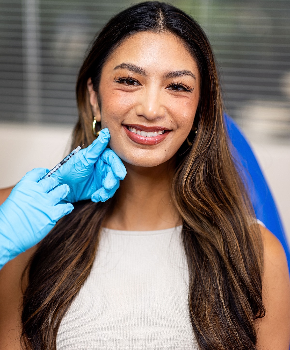 Smiling woman in white dress by a pool.