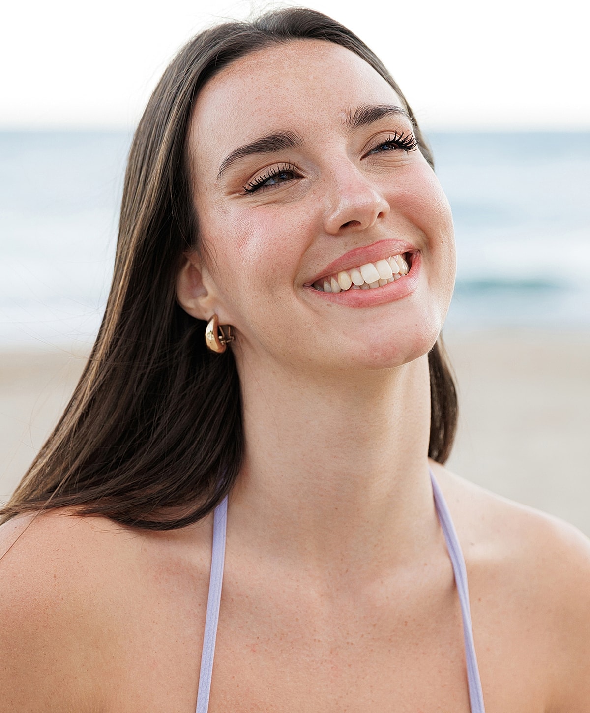 Woman smiling in sunset by the beach.