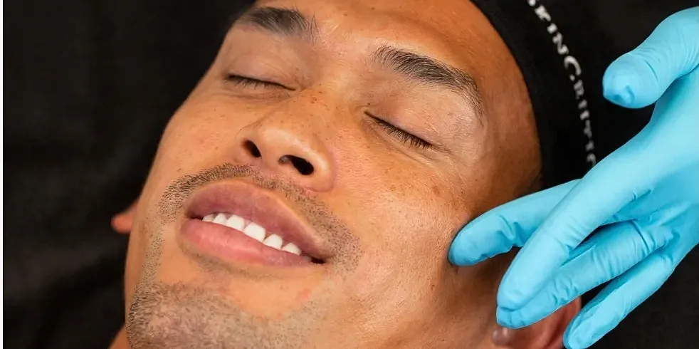 Male patient receiving facial treatment or massage.