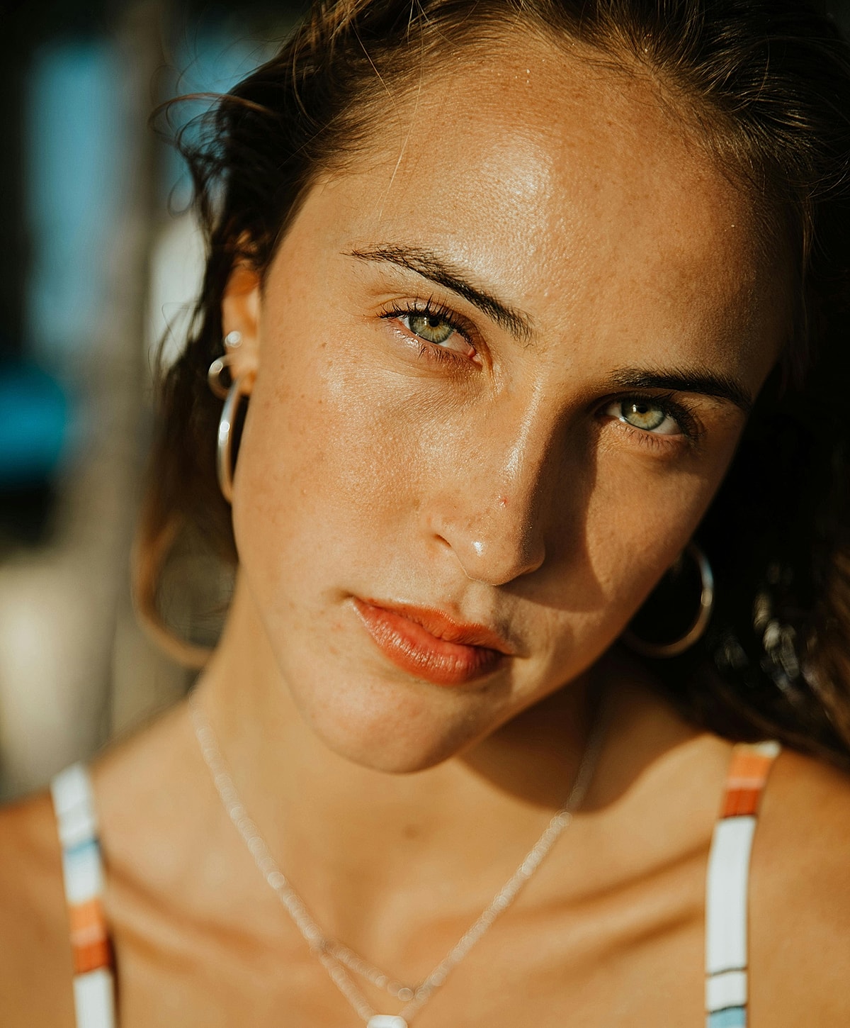 Smiling woman in white dress by a pool.