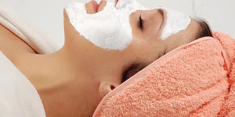 Woman relaxing with a facial mask treatment.