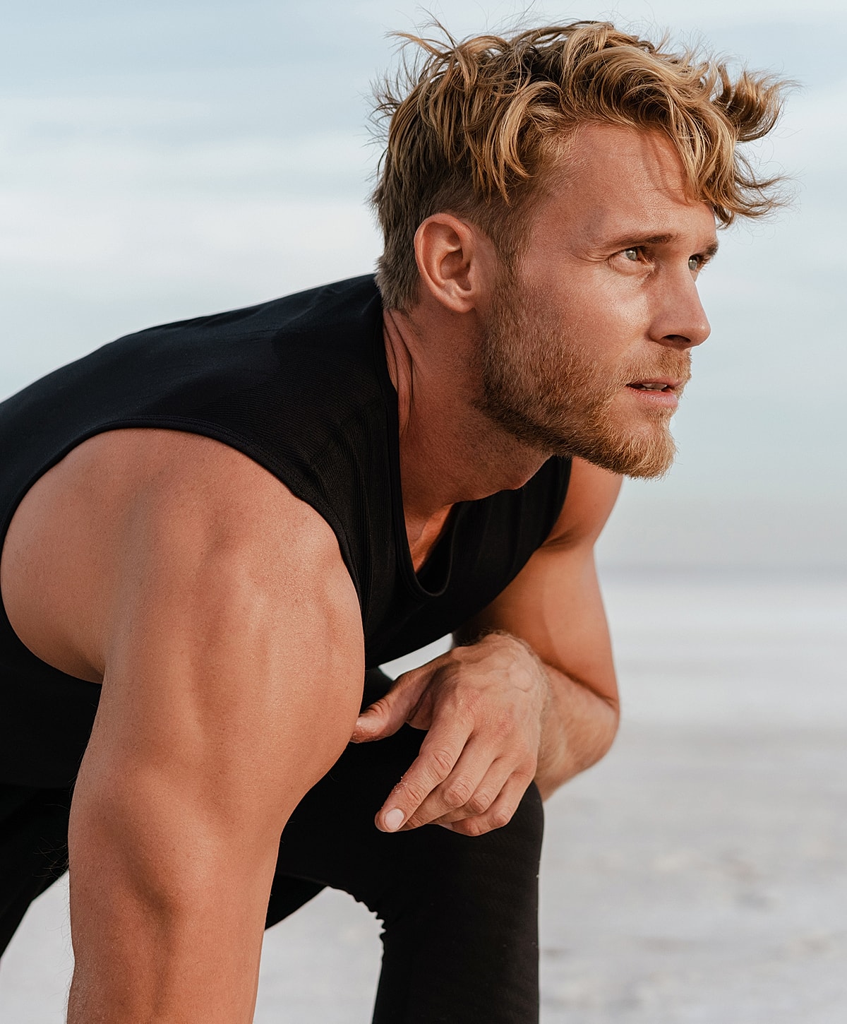 Smiling woman in white dress by a pool.