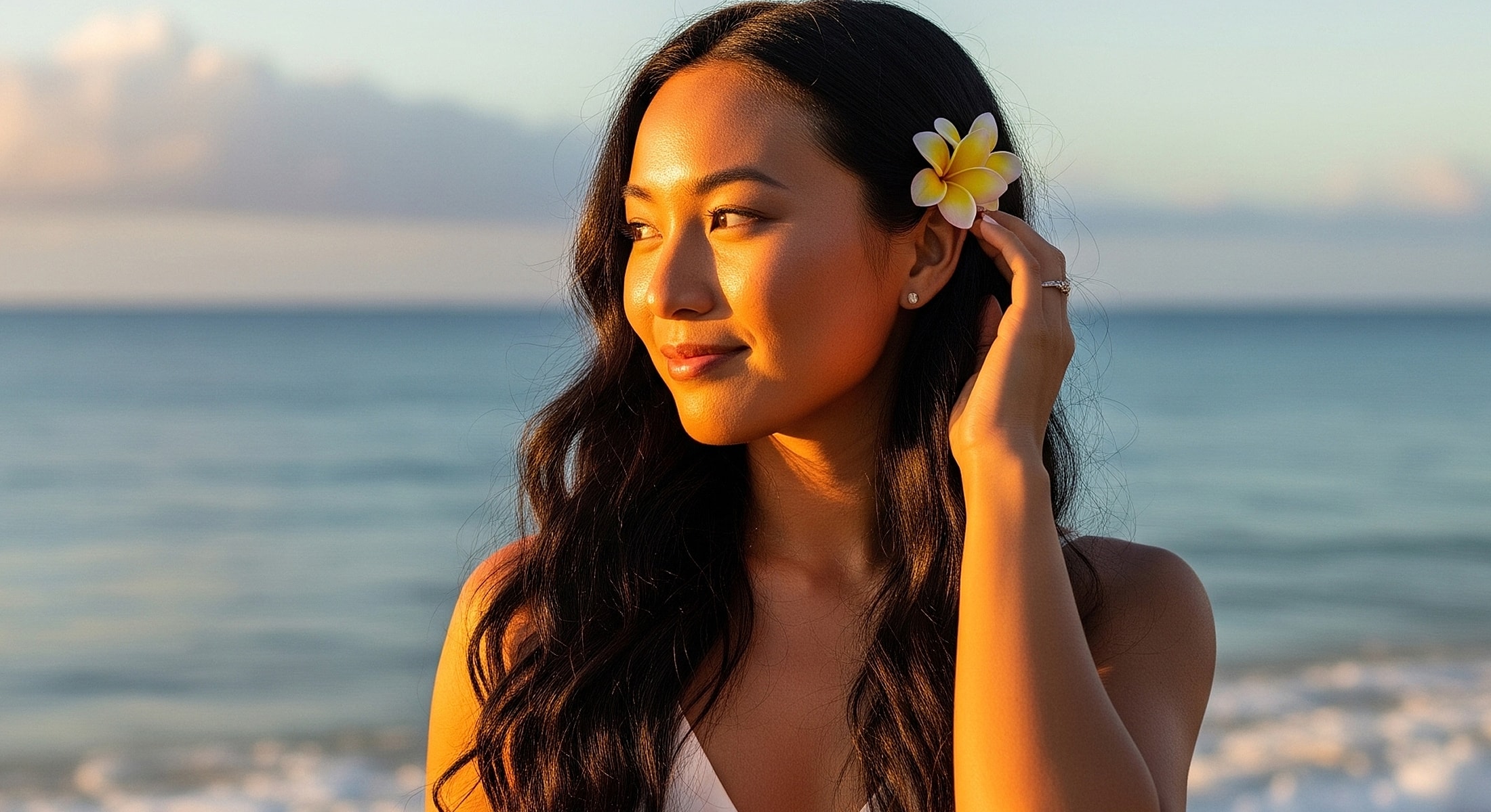 Woman with flower by the beach at sunset.
