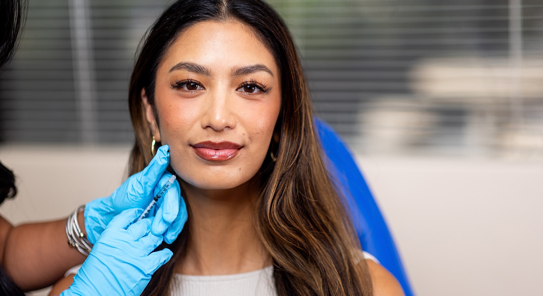 Woman receiving cosmetic treatment with syringe.